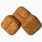 Three Carprofen Soft Chewable Tablets for dogs on a white background.