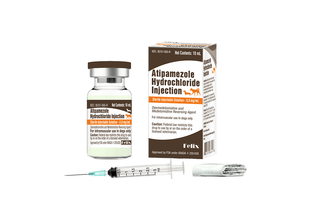 A 10 mL glass vial and the packaging box for Atipamezole Hydrochloride Injection with a small medical syringe and a folded product insert resting in front of the vial and packaging box.